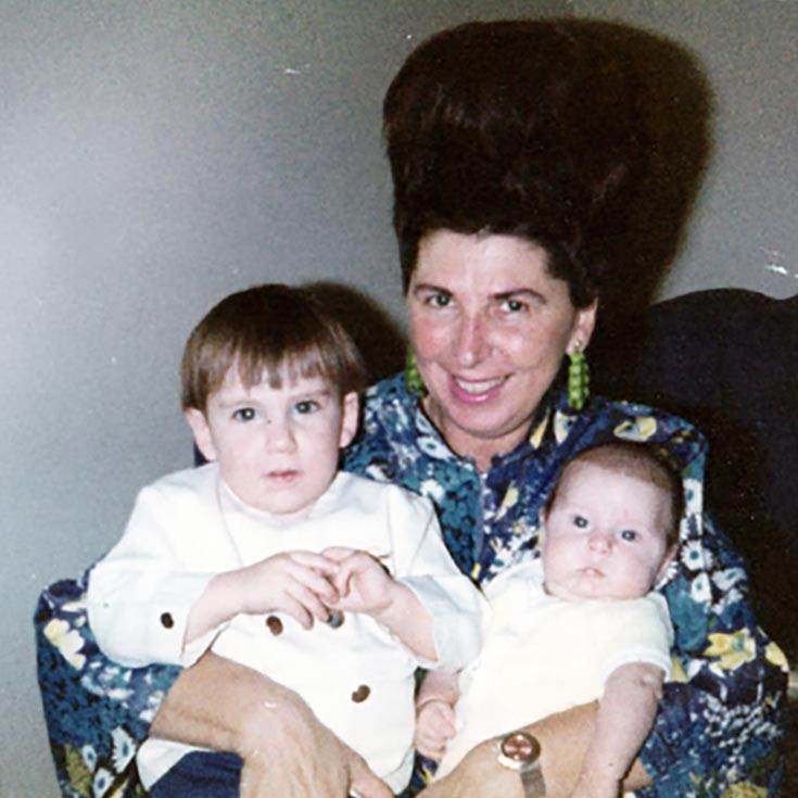 Brigitte holding her grandchildren in an old photo